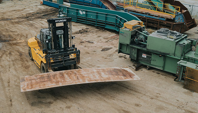 HSC yard with recycling equipment and fork lift moving steel plate